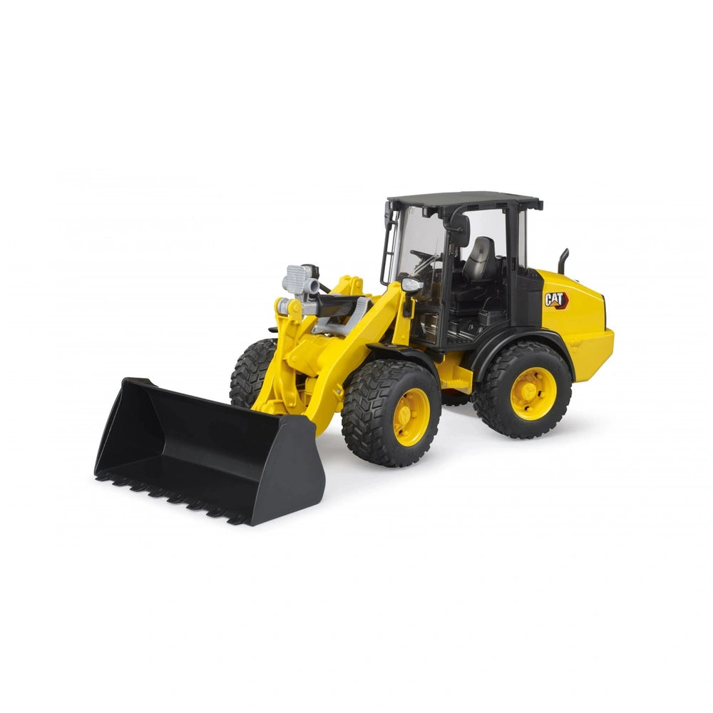 Yellow Bruder Cat Wheel Loader toy with articulated steering, black cabin, and a functional front shovel on a white background.