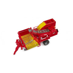 Red Bruder Grimme potato digger toy with yellow sorting belt and imitation potatoes on a white background.