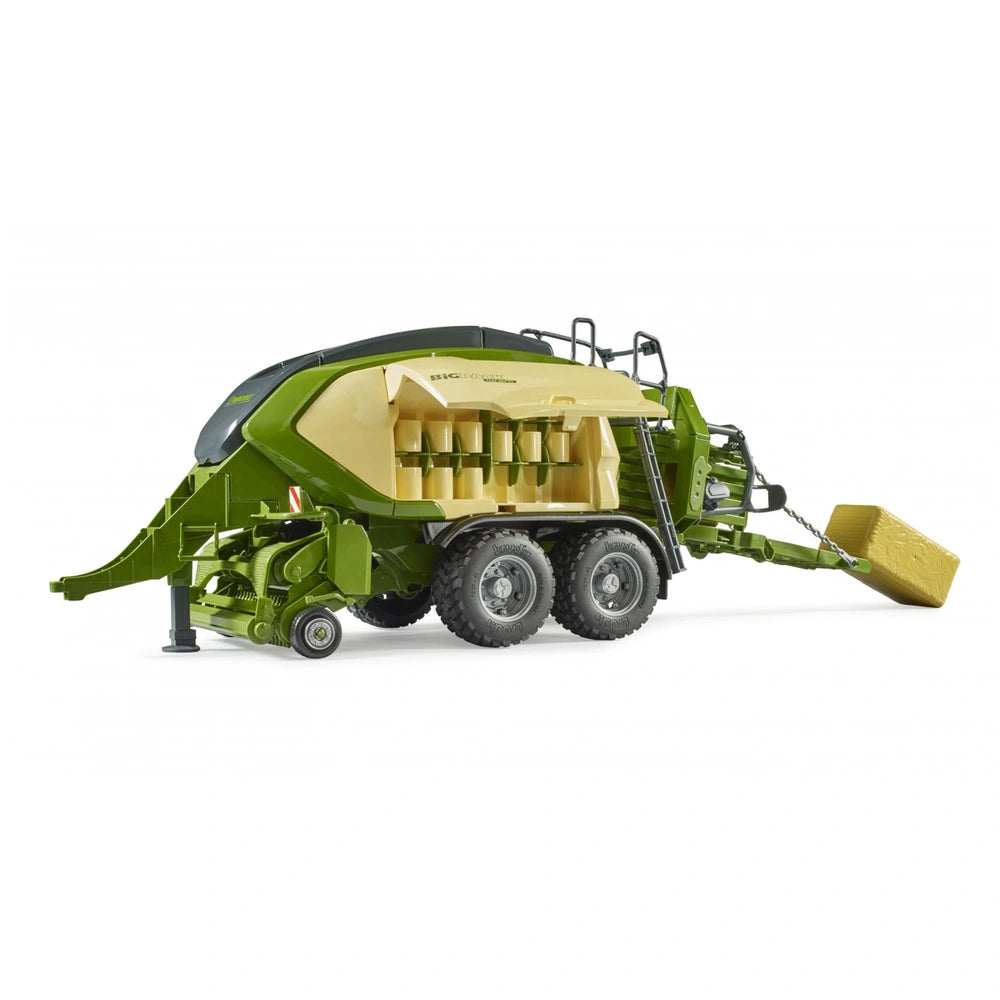 Green and yellow Bruder Krone Big Pack baler toy with detailed parts and attached hay bale on white background.