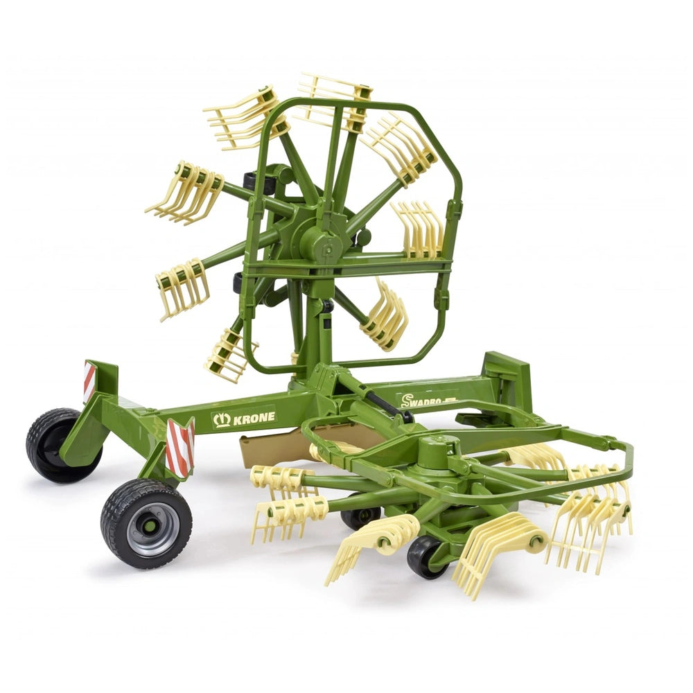 Green Bruder Krone toy swather with dual rotary design, featuring beige prong arms and realistic farm machinery details.