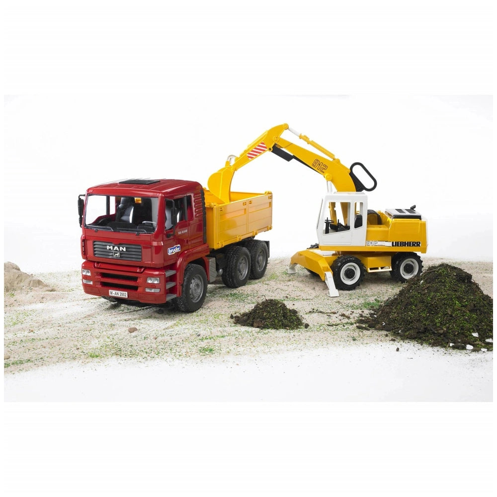 Yellow Liebherr excavator transferring dirt into red MAN truck on a sandy surface.