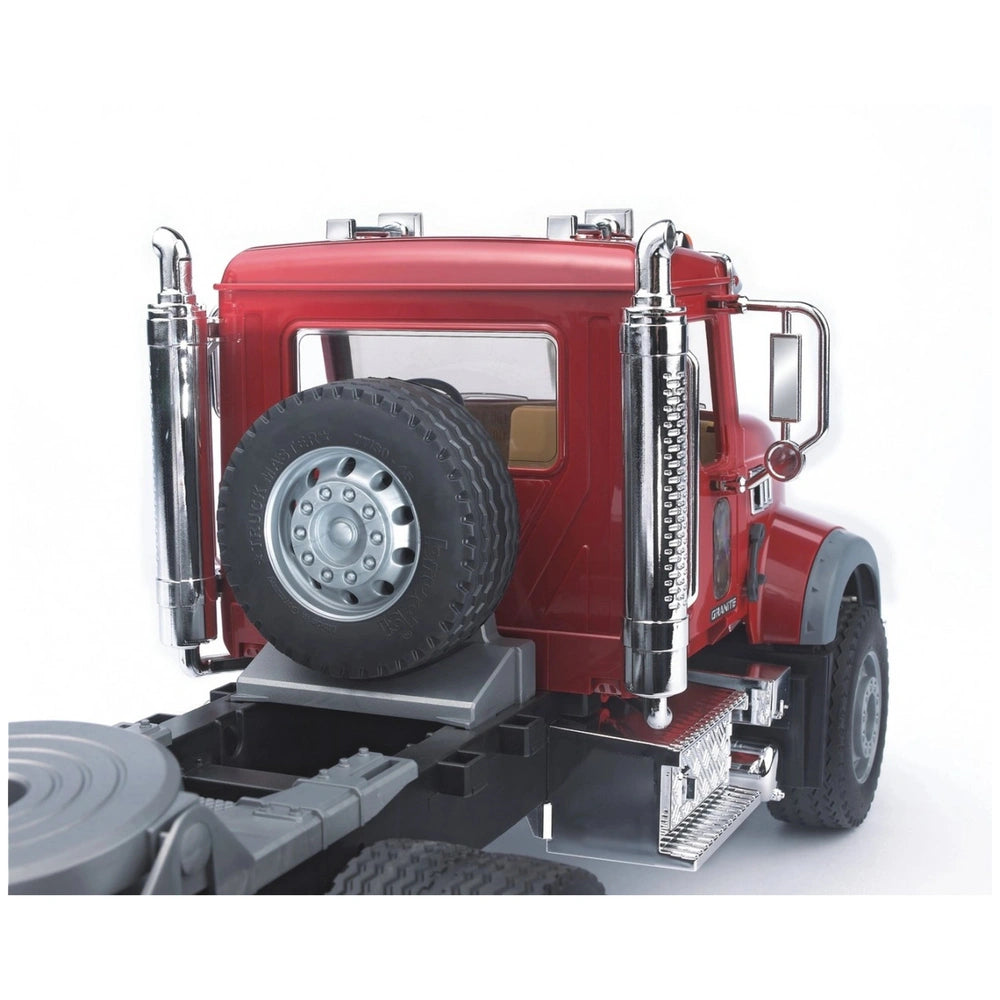 Red Bruder MACK Granite truck rear view with spare tire and chrome exhausts, highlighting realistic truck details.