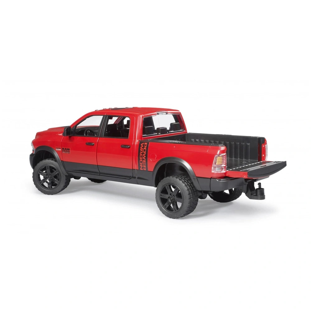 Red Bruder RAM 2500 Power Wagon toy truck with open tailgate, black wheels, and realistic design, angled rear view.