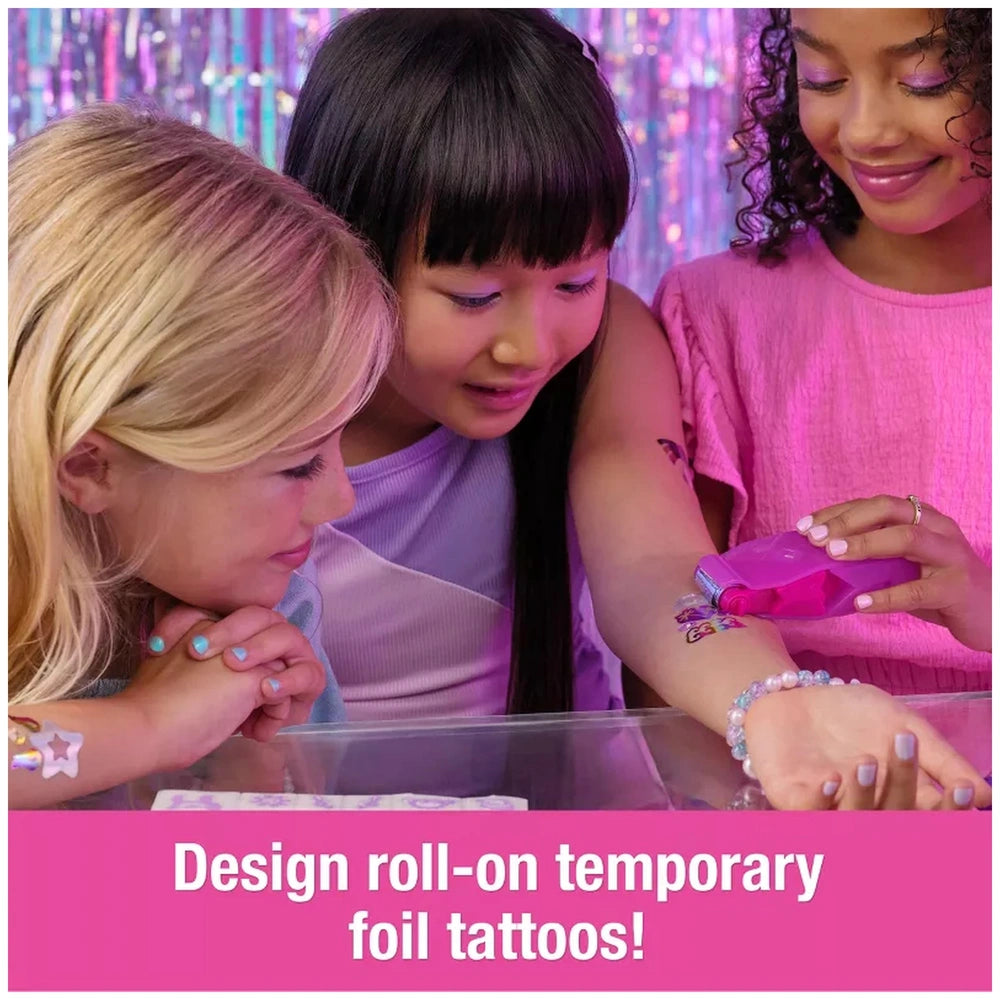 Cool Maker Shimmer Me Body Art Set showcases girls excitedly viewing colorful temporary tattoo designs on a smartphone.