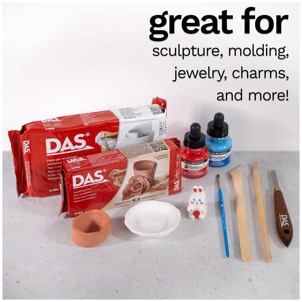 DAS Modeling Clay in red packaging with clear window, featuring a blue paintbrush and white palette on a surface.