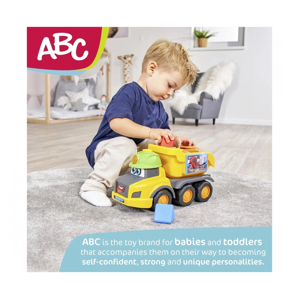 Dickie ABC Fendit Animal Trailer play vehicle packaging features a child with a yellow toy truck on a gray carpet.