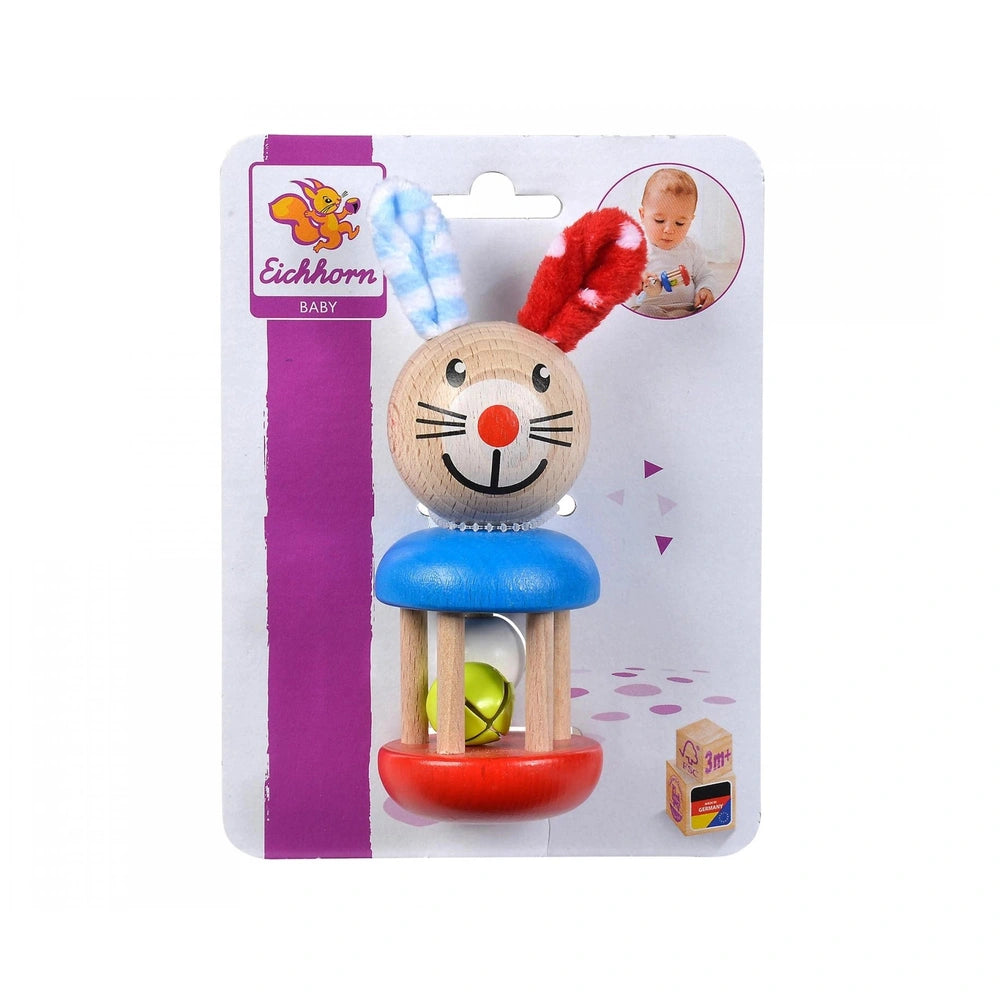 Eichhorn Baby Wooden Rattle Rabbit features a smiling face, red nose, blue seat, and green ball, packaged in glossy cardboard