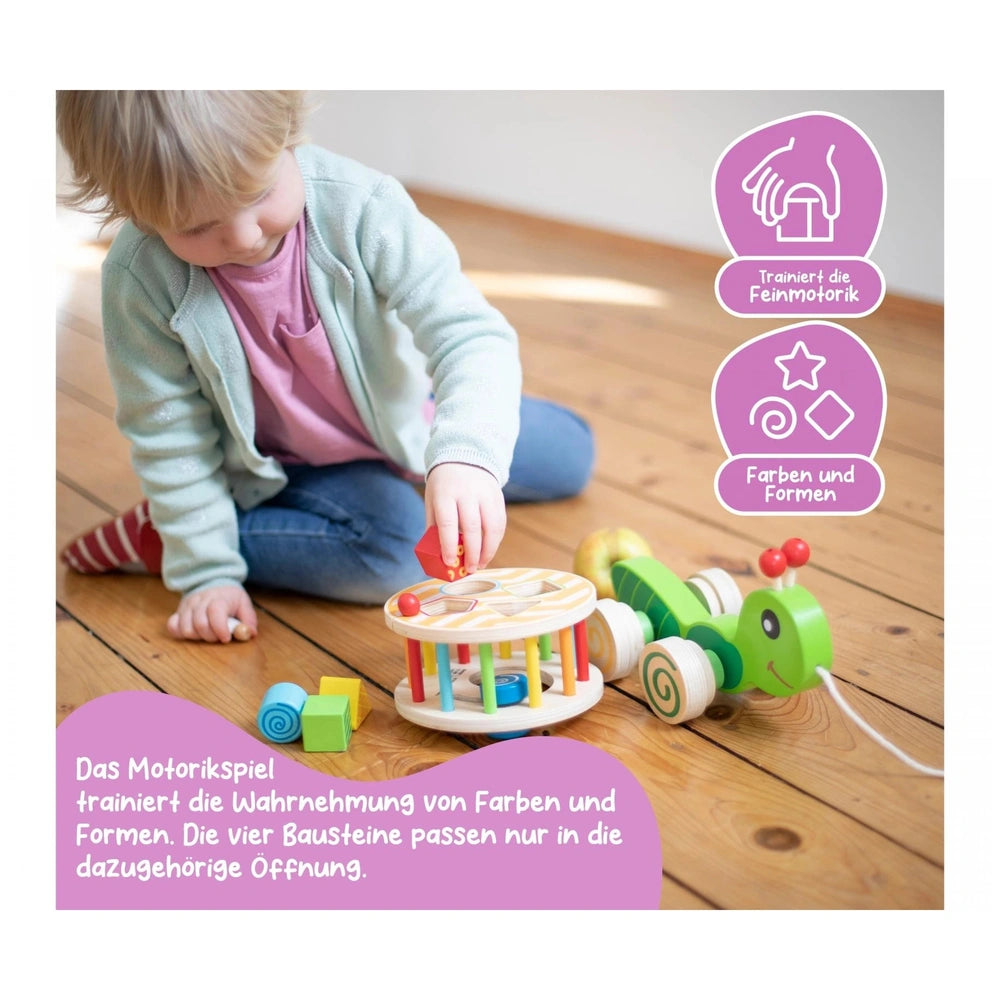 Eichhorn Color Pull-along Stacking Animal toy is being played with by a toddler on a wooden floor, surrounded by colorful toy