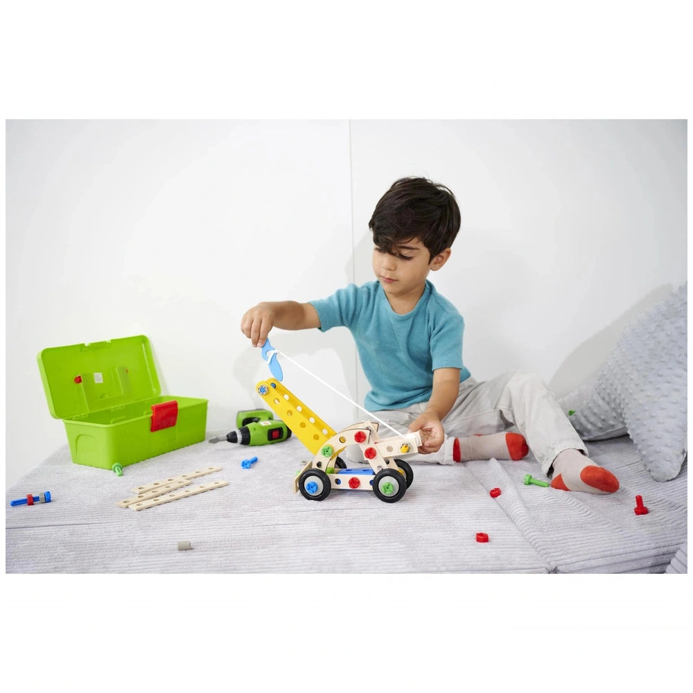 Eichhorn Constructor 4in1 construction set displayed with a child in a blue shirt, holding a colorful toy on a white surface.