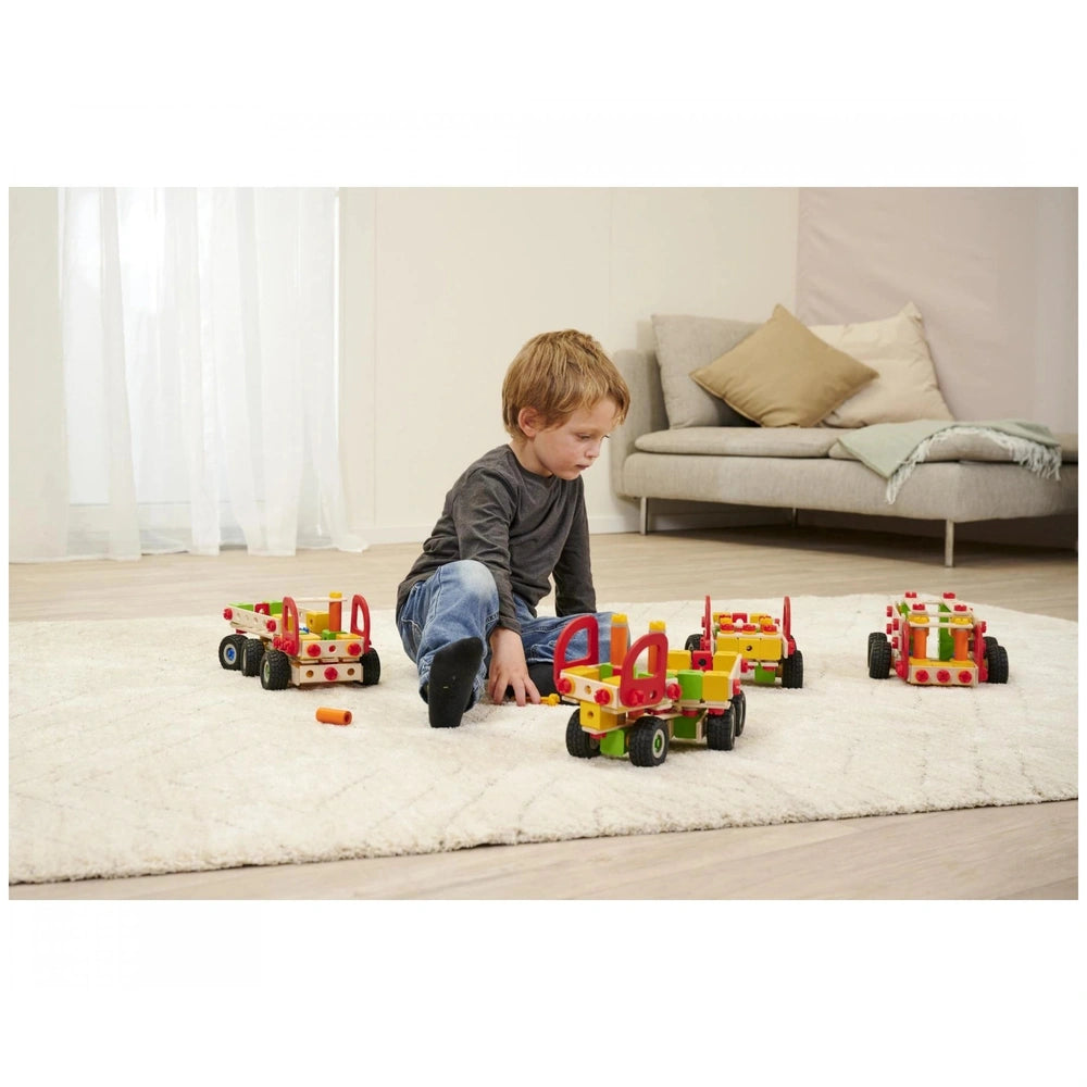 Eichhorn Constructor Truck set with 135 colorful pieces is being played with by a focused child on a soft white rug.