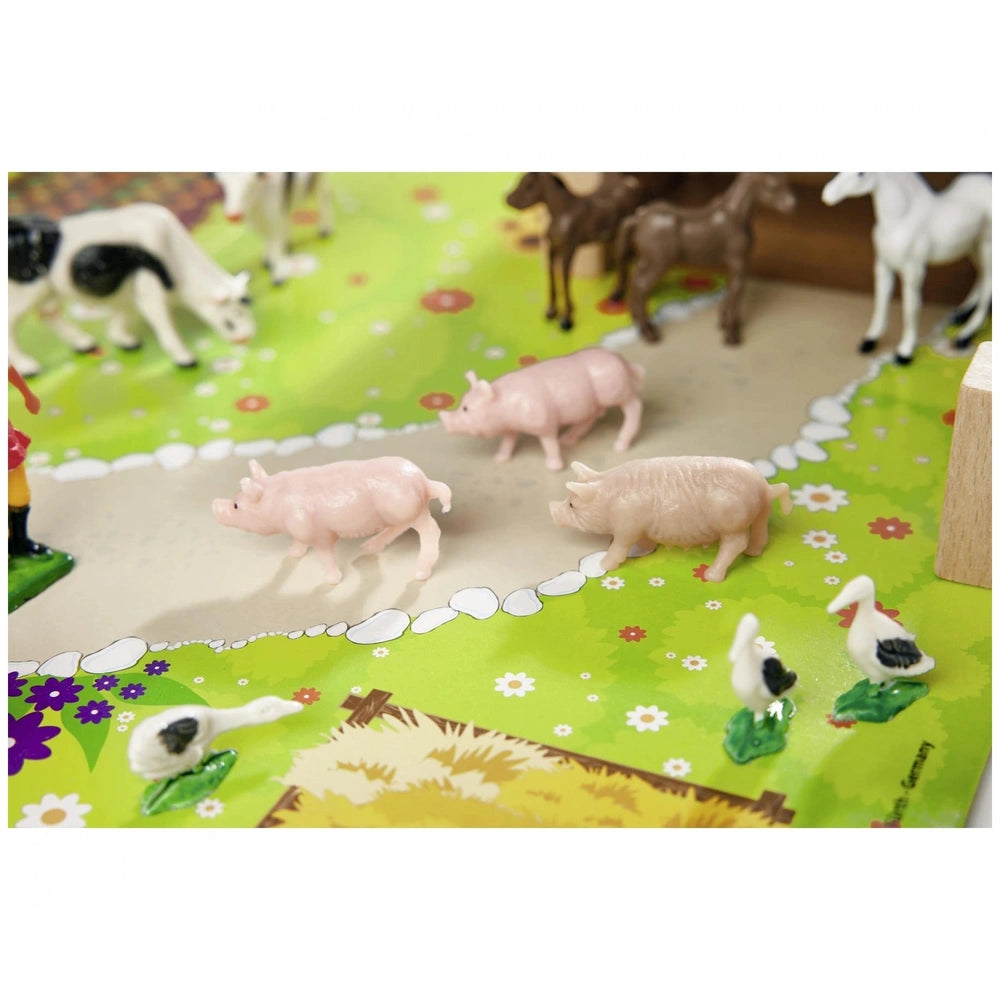 Eichhorn Little Farm Set featuring colorful toy animals on a vibrant green play mat with floral patterns.