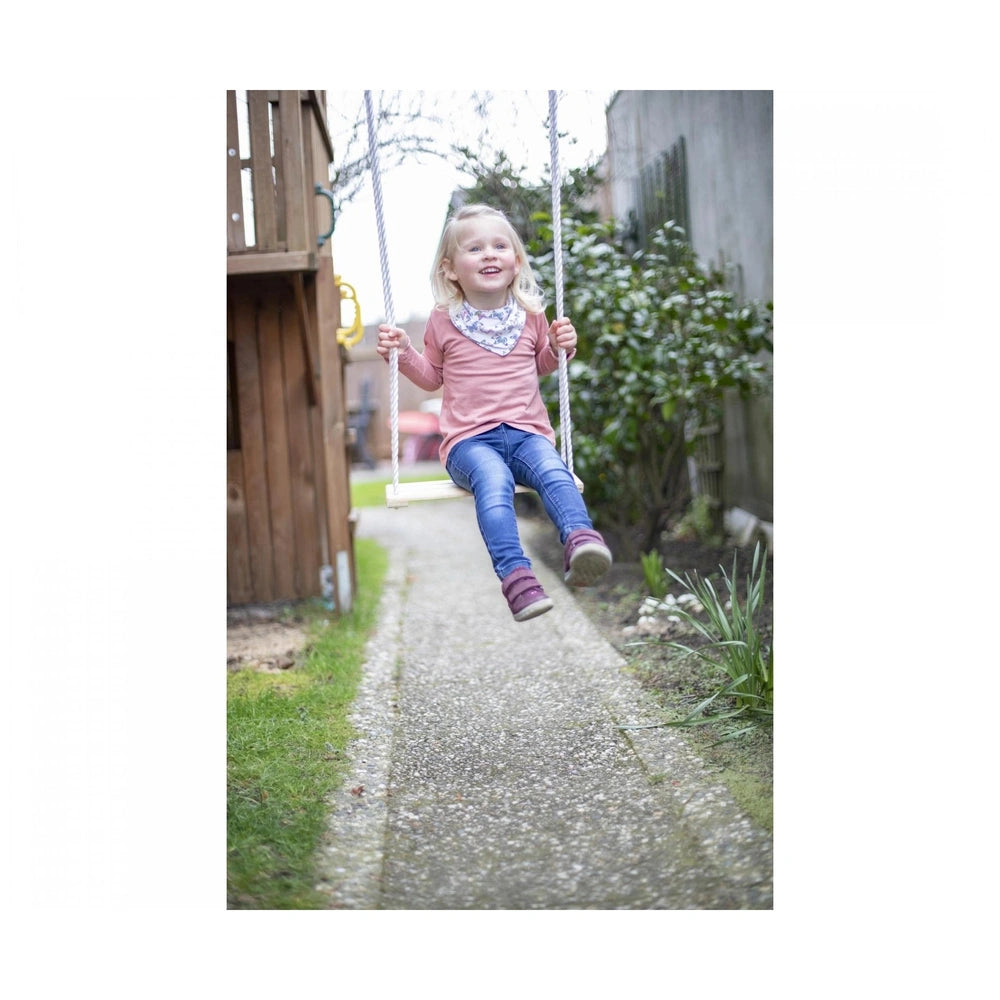 Eichhorn Outdoor Wooden Swing with a young girl in a pink top joyfully swinging in a backyard setting.