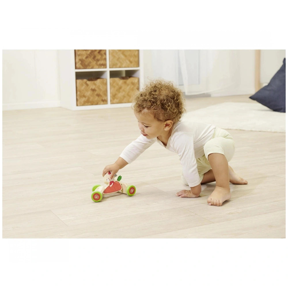 Eichhorn push vehicle: toddler playing with a red heart toy car on a wooden floor in a cozy, well-lit room.