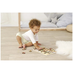 Eichhorn Woodland animals puzzle with toddler playing on wooden floor, surrounded by scattered puzzle pieces.