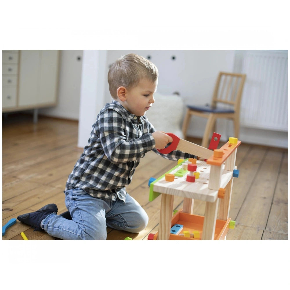 Eichhorn Work Bench showcases a child playing with a wooden construction set, hammering with focus in a cozy room.