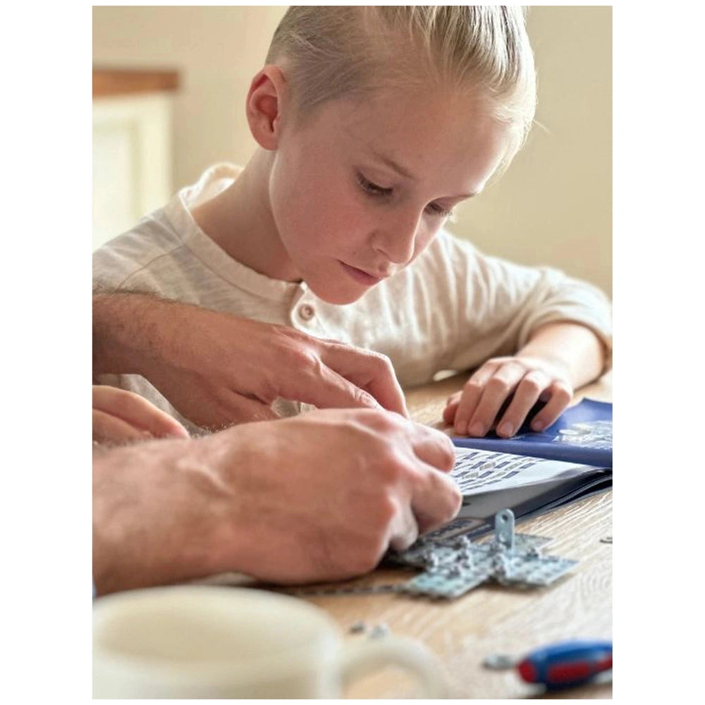 Eitech Speed Racer construction set being enjoyed by a person with blonde hair, seated at a wooden table.
