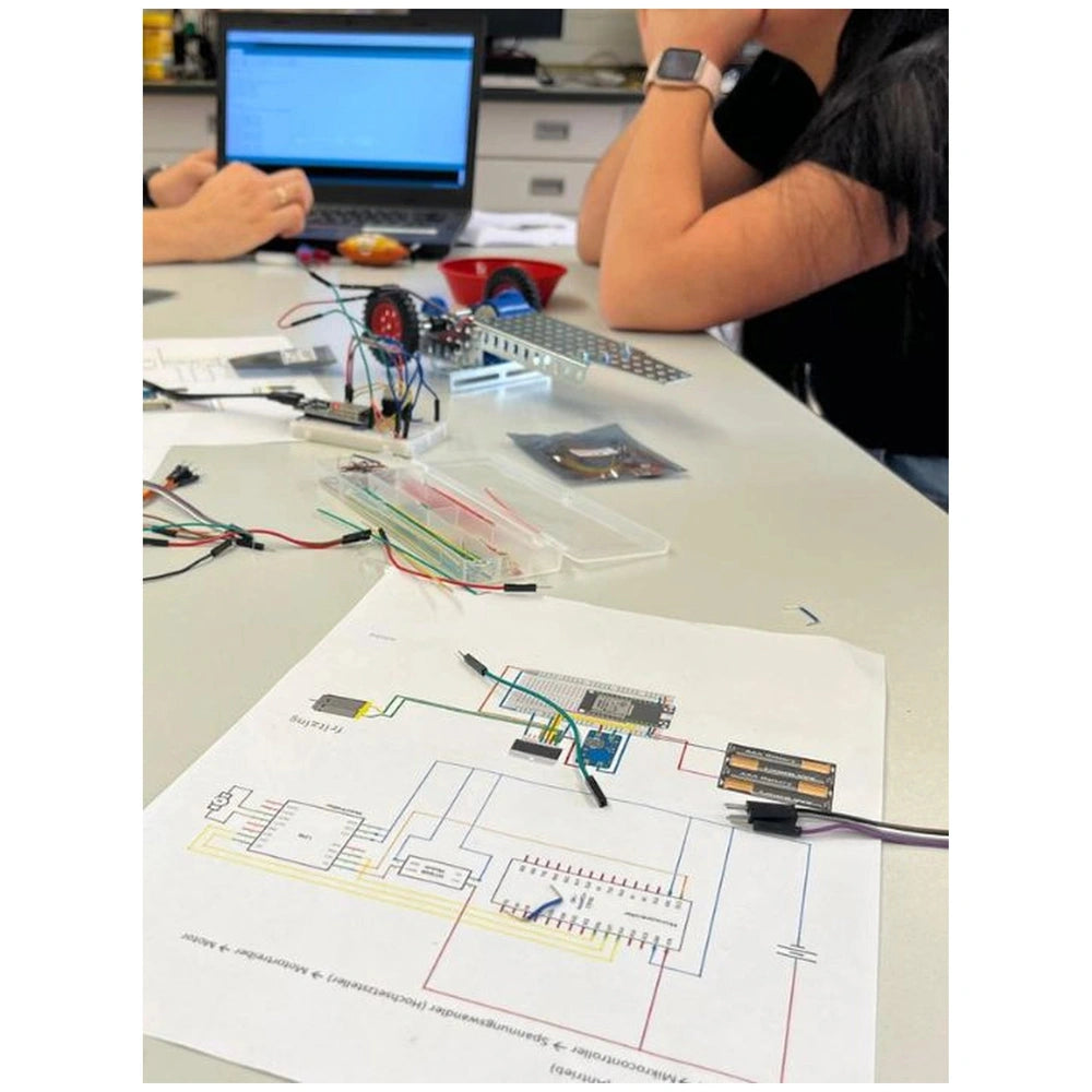 Eitech Speed Racer construction set displayed on a light table with a black laptop, silver watch, and colorful electronic com