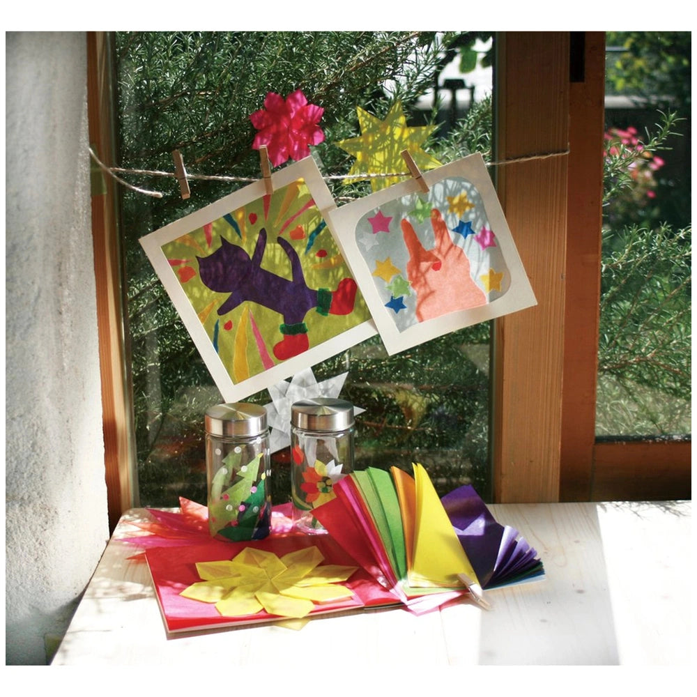 Folia transparent paper block featuring multi-coloured sheets with flowers and stars displayed on a wooden table.