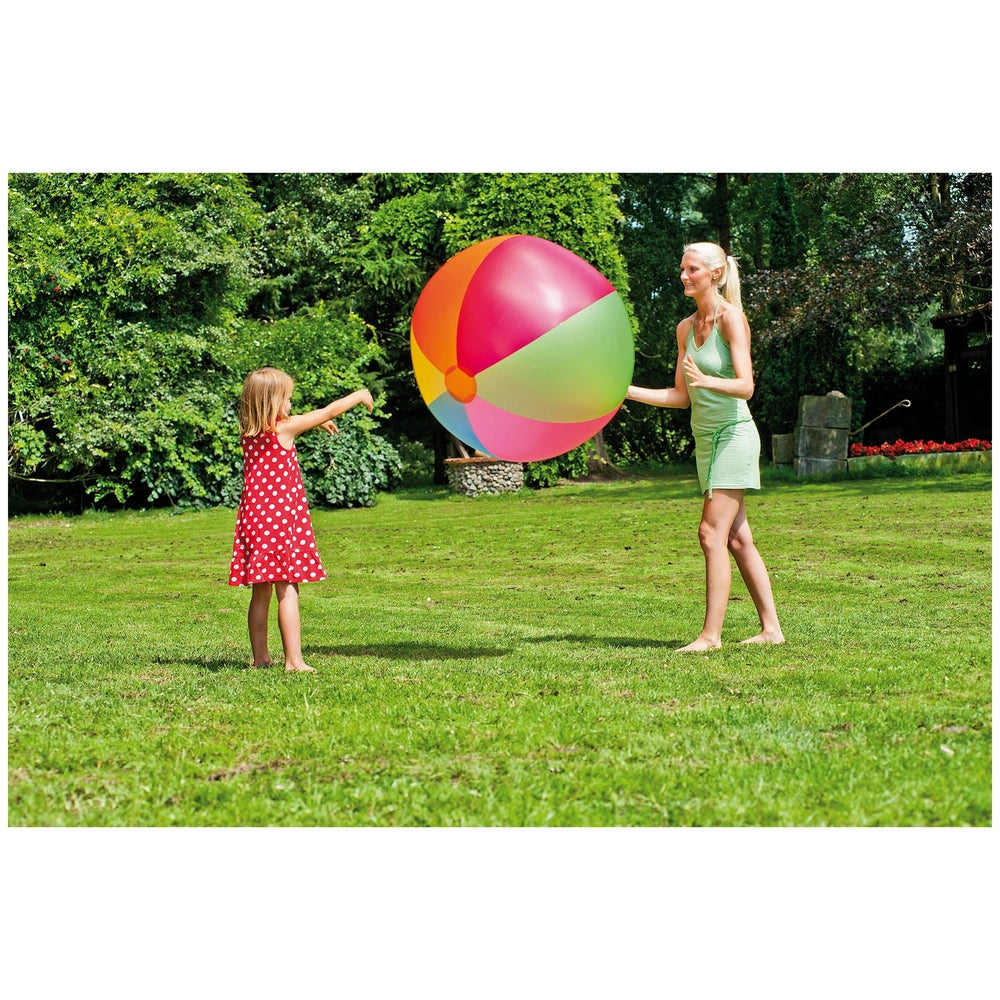 Happy People Beach Ball XXL 85 cm held by a woman in a green dress with a girl in a red polka dot dress on vibrant green gras
