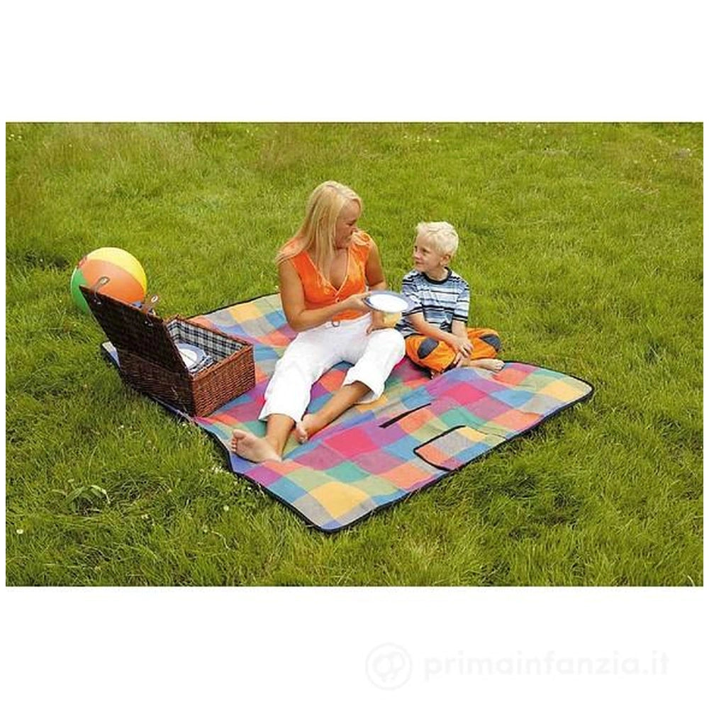 Happy People picnic blanket in multicolored checkered pattern on green grass, with two people enjoying a picnic.
