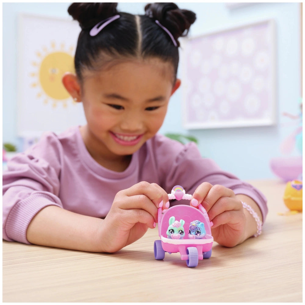Hatchimals Alive Hatch N’ Stroll Playset is held by a smiling girl in a pink top, seated at a wooden table.