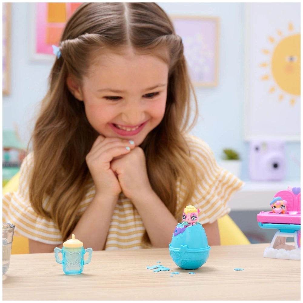 Hatchimals Alive Hungry Hatchimals Playset displayed on a table as a young girl smiles while engaging with the toys.