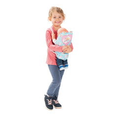 Heless Doll Carrier features a girl in a pink top and blue jeans holding a floral-patterned stuffed animal with a pink heart.