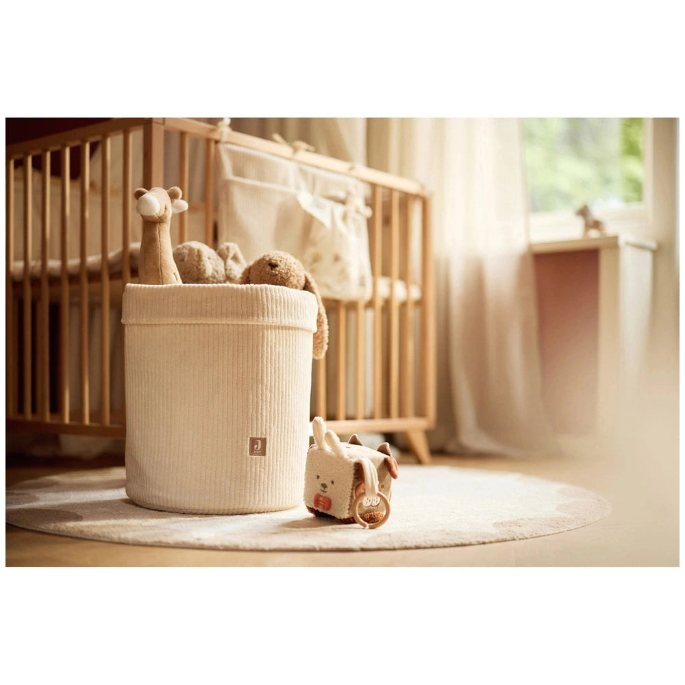 Jollein Activity Cube features a wooden crib with white bedding and multiple white stuffed animal friends in a cozy setting.