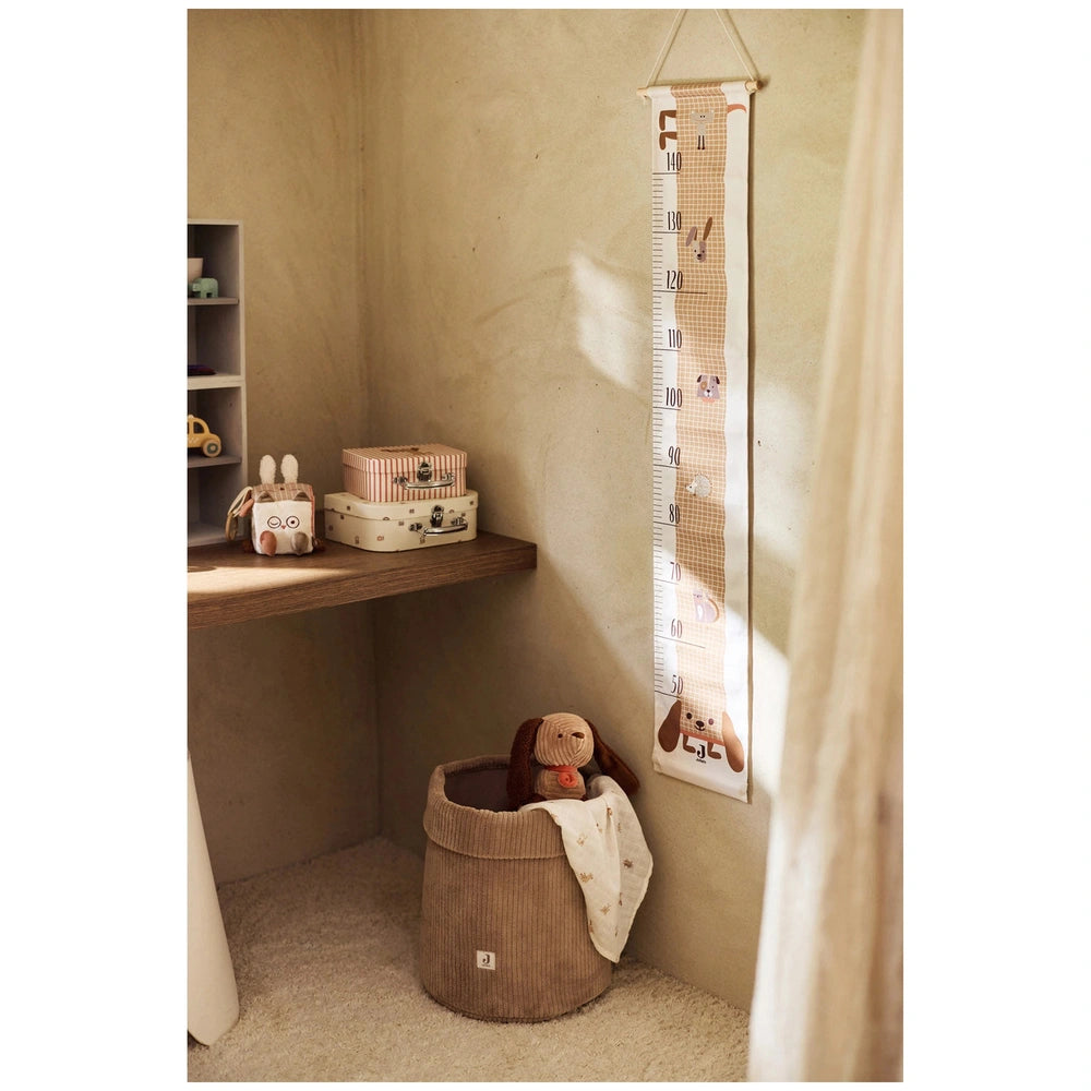 Jollein Activity Cube Animal Friends displayed on a wooden shelf against a beige wall with various cartoon character wall han