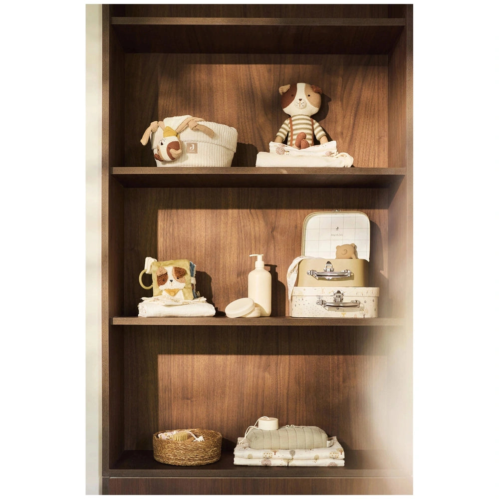 Jollein Activity Cube Tiny Park displayed on a brown wooden shelf with various white and beige fabric items and toys.
