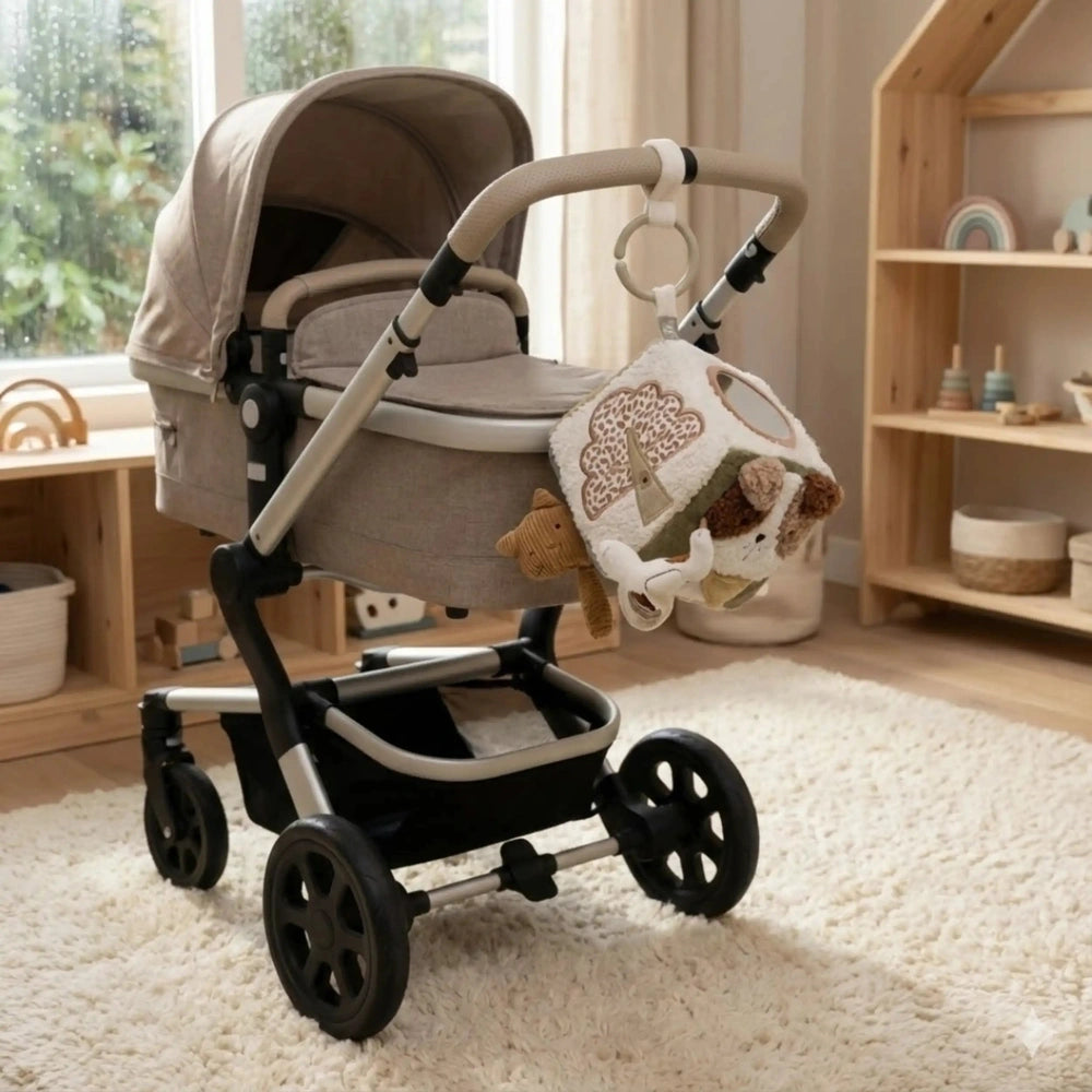 Jollein Activity Cube Tiny Park baby activity toy placed in a light beige stroller with black and silver frame on a light car