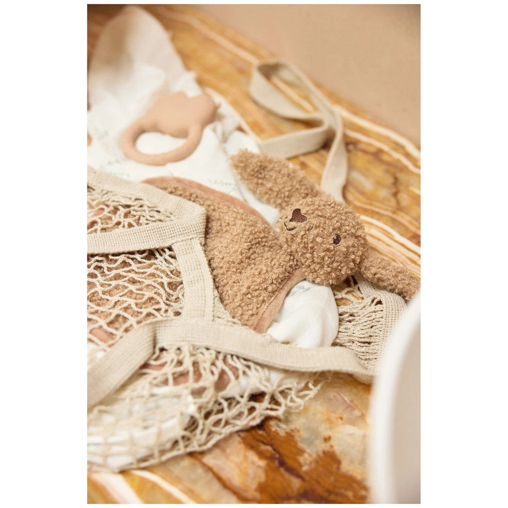 Jollein pacifier cloth bunny in brown next to a white bag, featured in a close-up centered layout.