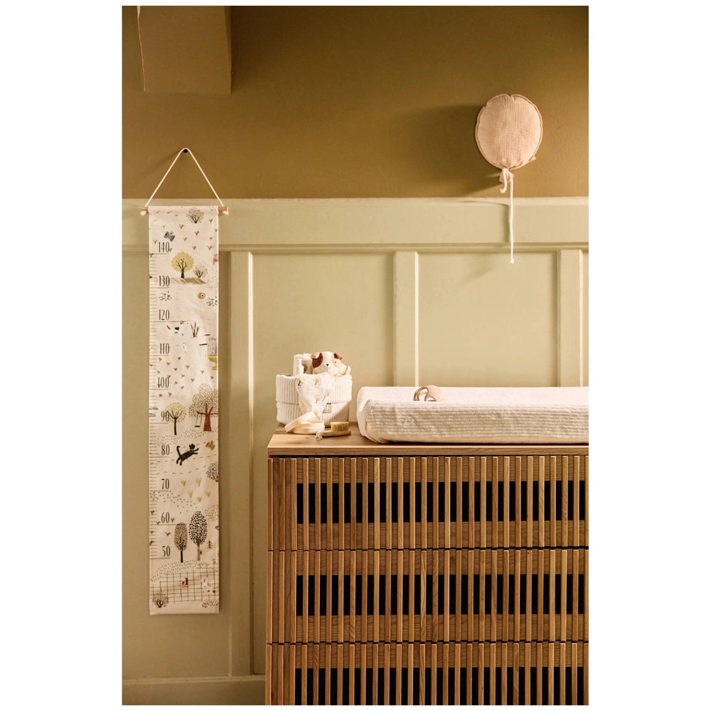 Jollein pacifier cloth Mick on a wooden dresser, featuring white patterned fabric and a hanging matte plastic balloon.