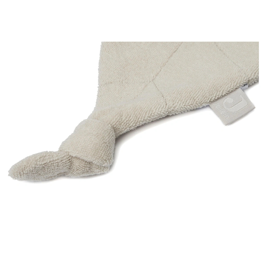 Jollein pacifier cloth in soft light beige fabric, featuring a textured cylindrical shape and an attached tag.