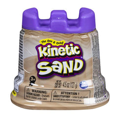 Kinetic Sand container with a brown body, purple lid, and a colorful label featuring brand name and caution symbols.