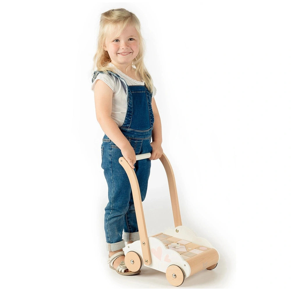 Label-Label educational baby walker with a young girl in blue overalls, holding a wooden handle, set against a white backgrou