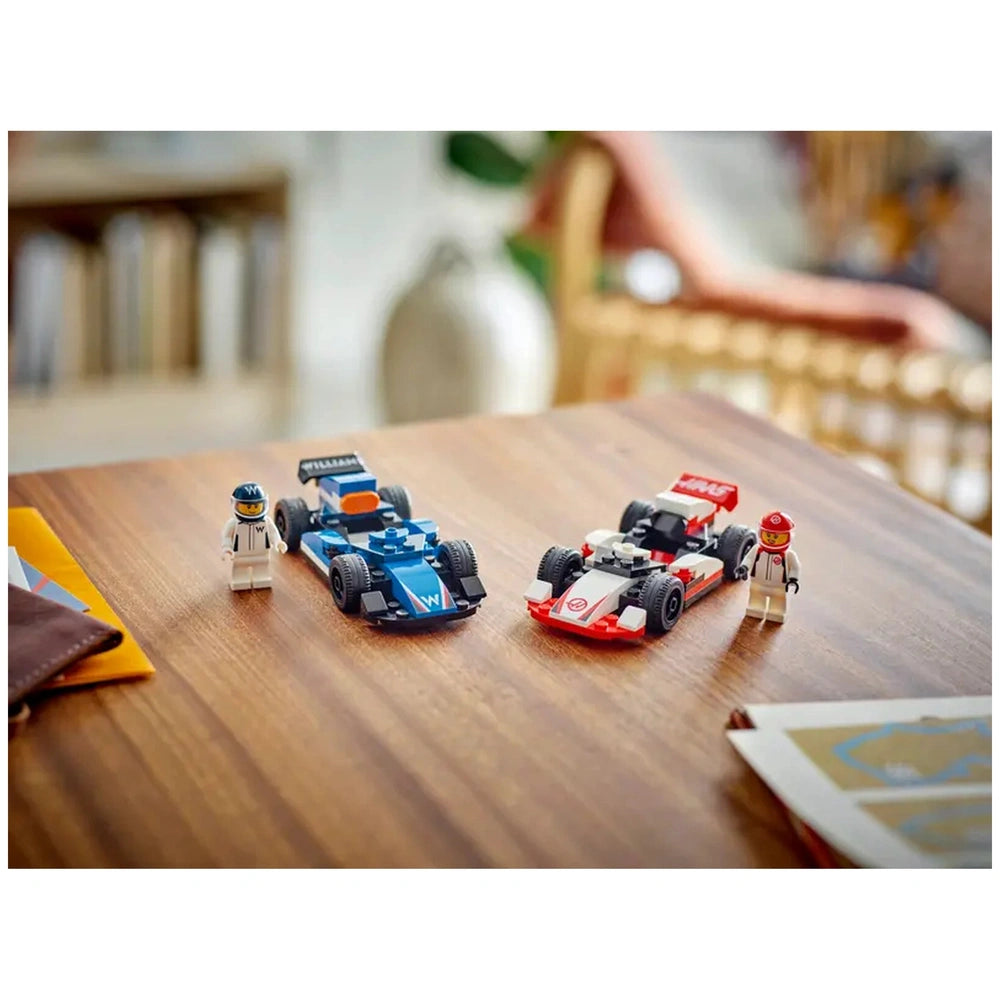 LEGO® City F1® Williams Racing and Haas F1® race cars on a wooden table, alongside two driver minifigures ready for action.