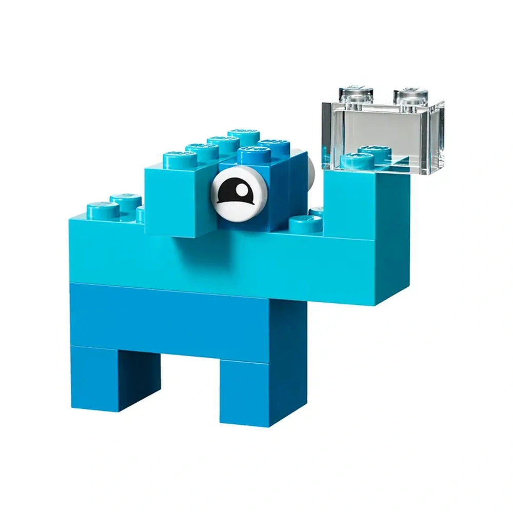 Bright blue LEGO building blocks shaped like a whimsical creature with large eyes and a transparent block in its hand, set against a white background.