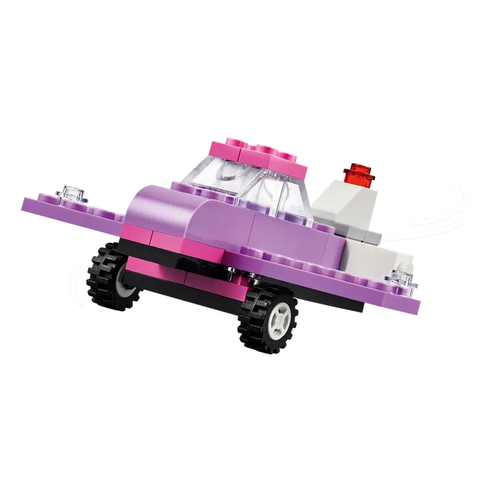 A colorful LEGO® vehicle in shades of purple with a clear windshield, red light, and black wheels, showcased from a dynamic angle.