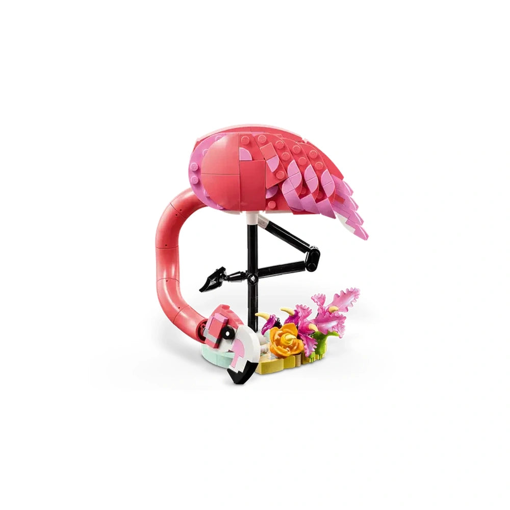 LEGO Creator 3in1 pink flamingo construction set, featuring vibrant pink and purple bricks, standing on a black stand with colorful flowers.