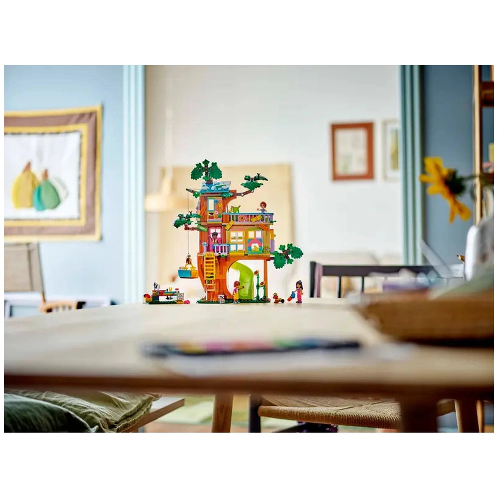 Colorful LEGO Friends Friendship Tree House Hangout set centered on a wooden table, featuring minidolls and nature elements, in a bright indoor space.