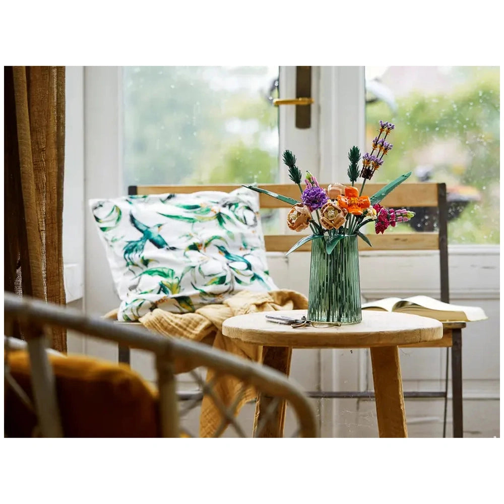Vibrant LEGO Flower Bouquet arranged in a green vase on a wooden table, surrounded by cozy decor and natural light from a nearby window.