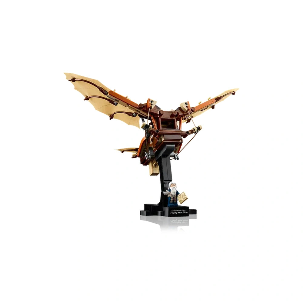 LEGO® Icons Leonardo da Vinci's Flying Machine construction set with intricate flappable wings, mounted on a black stand, alongside a mini-figure of Da Vinci holding a notebook.