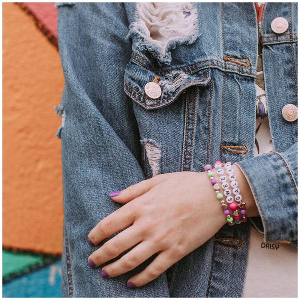 Block ‘N’ Rock Bracelets on a hand with purple nail polish, set against a blue denim jacket with metal buttons.