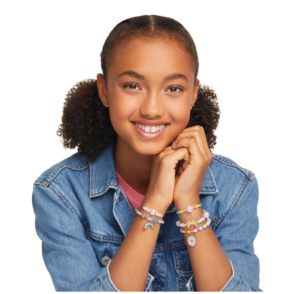 Rainbow Treasure Bracelets showcased on a young girl with curly dark brown hair, wearing a denim jacket and pink top, smiling