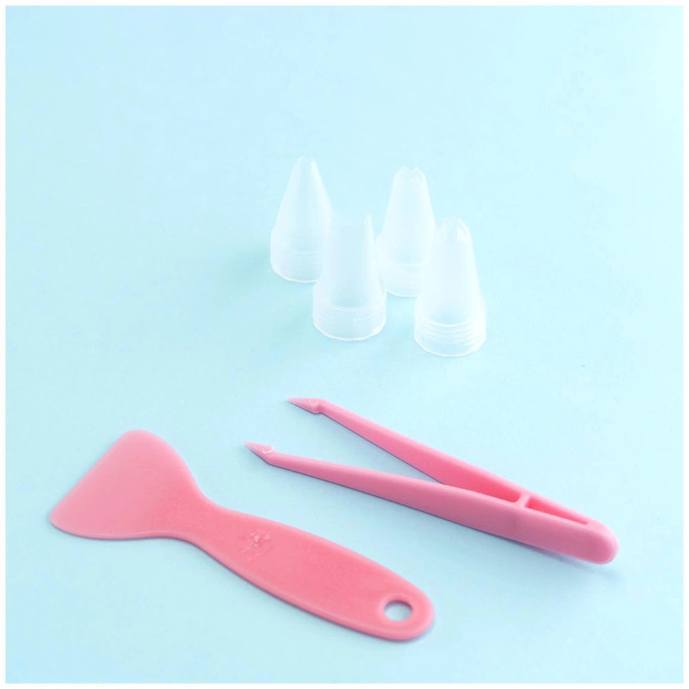 Momomi Decoden Kawaii Artist Creamy Diary Arts & Crafts Kit with pink-handled scissors on a smooth light blue surface.