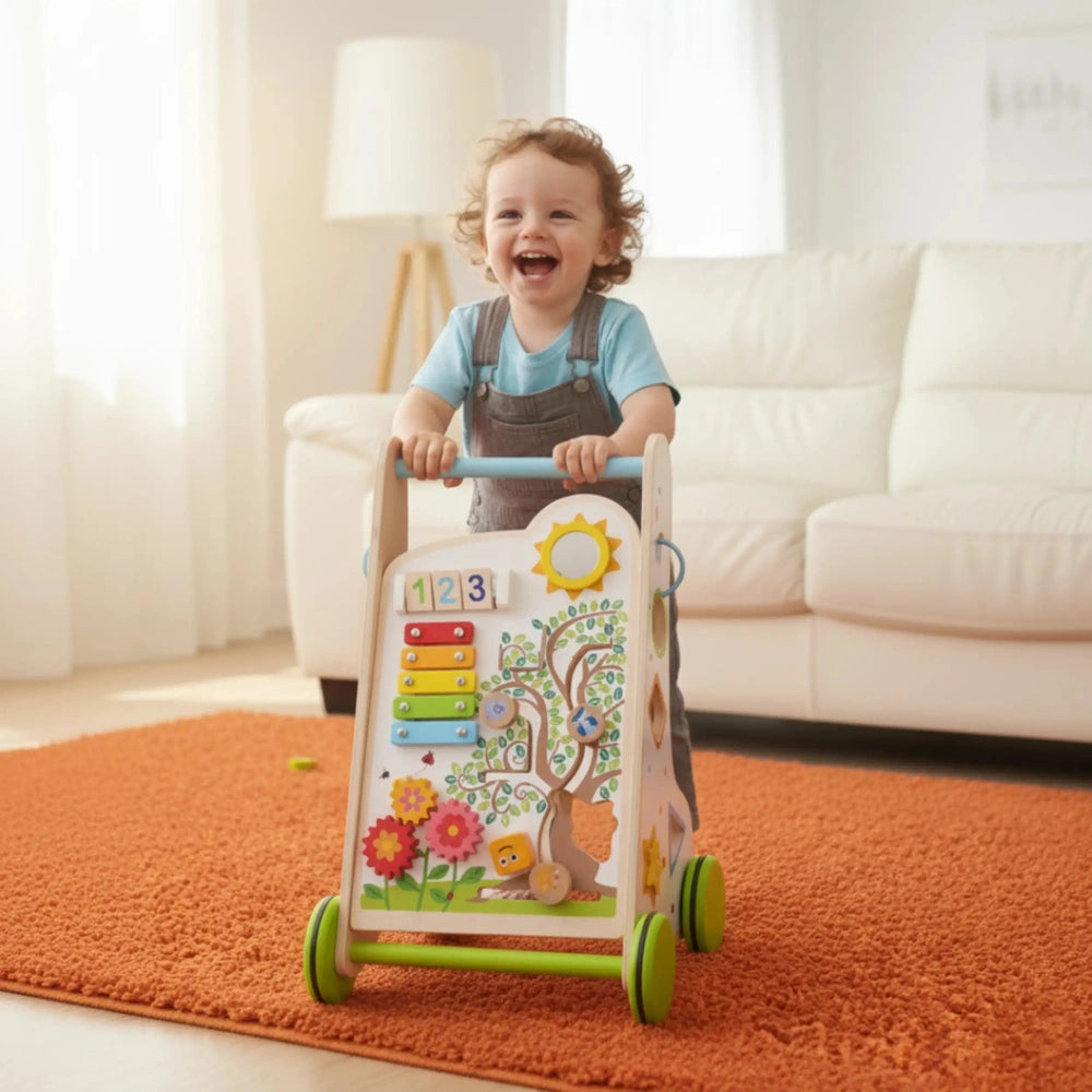 Red-haired child in blue overalls plays with a white wooden handle activity walker toy on a textured orange rug.