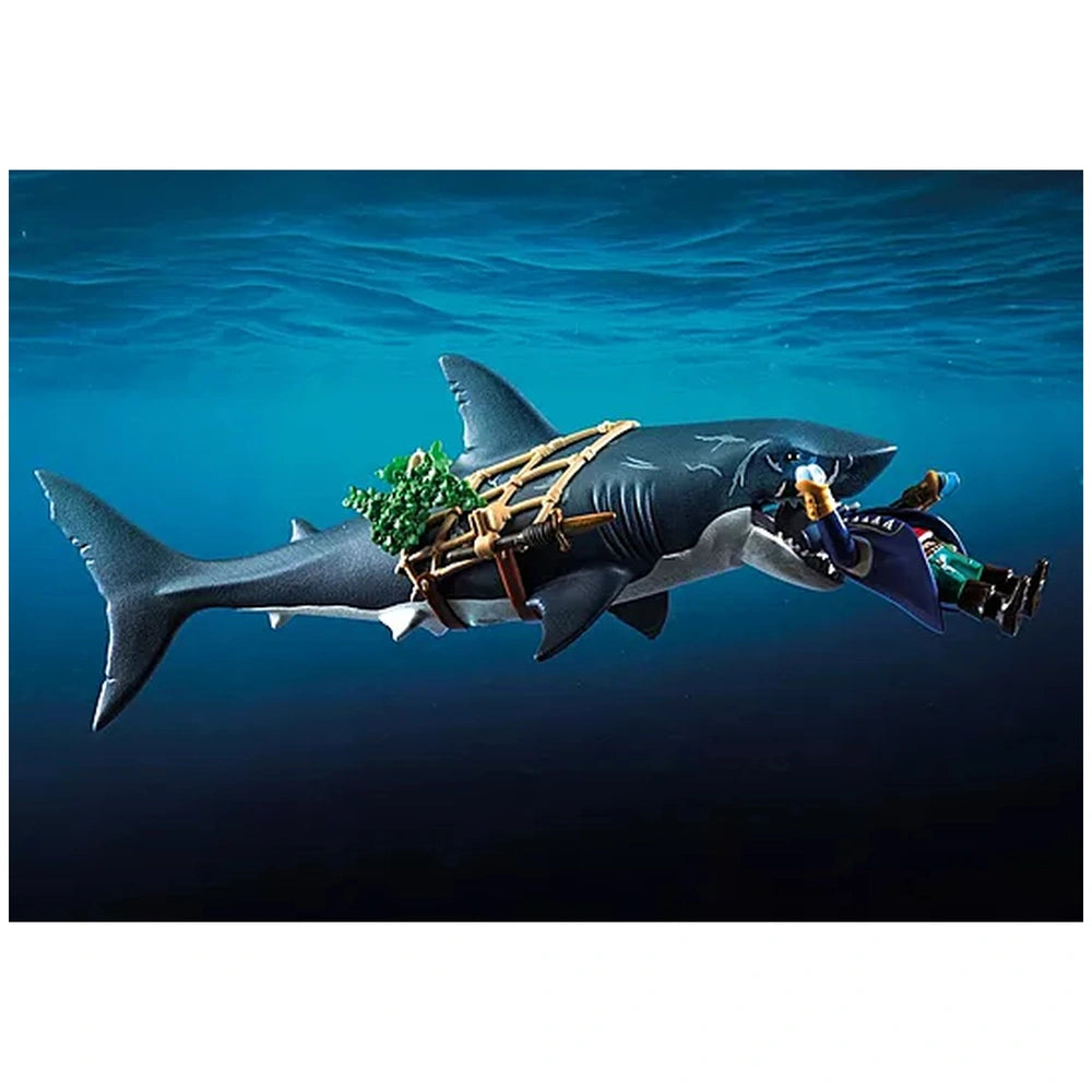 Giant Playmobil shark toy with glossy gray body, white teeth, and brown strap against a dark blue background.