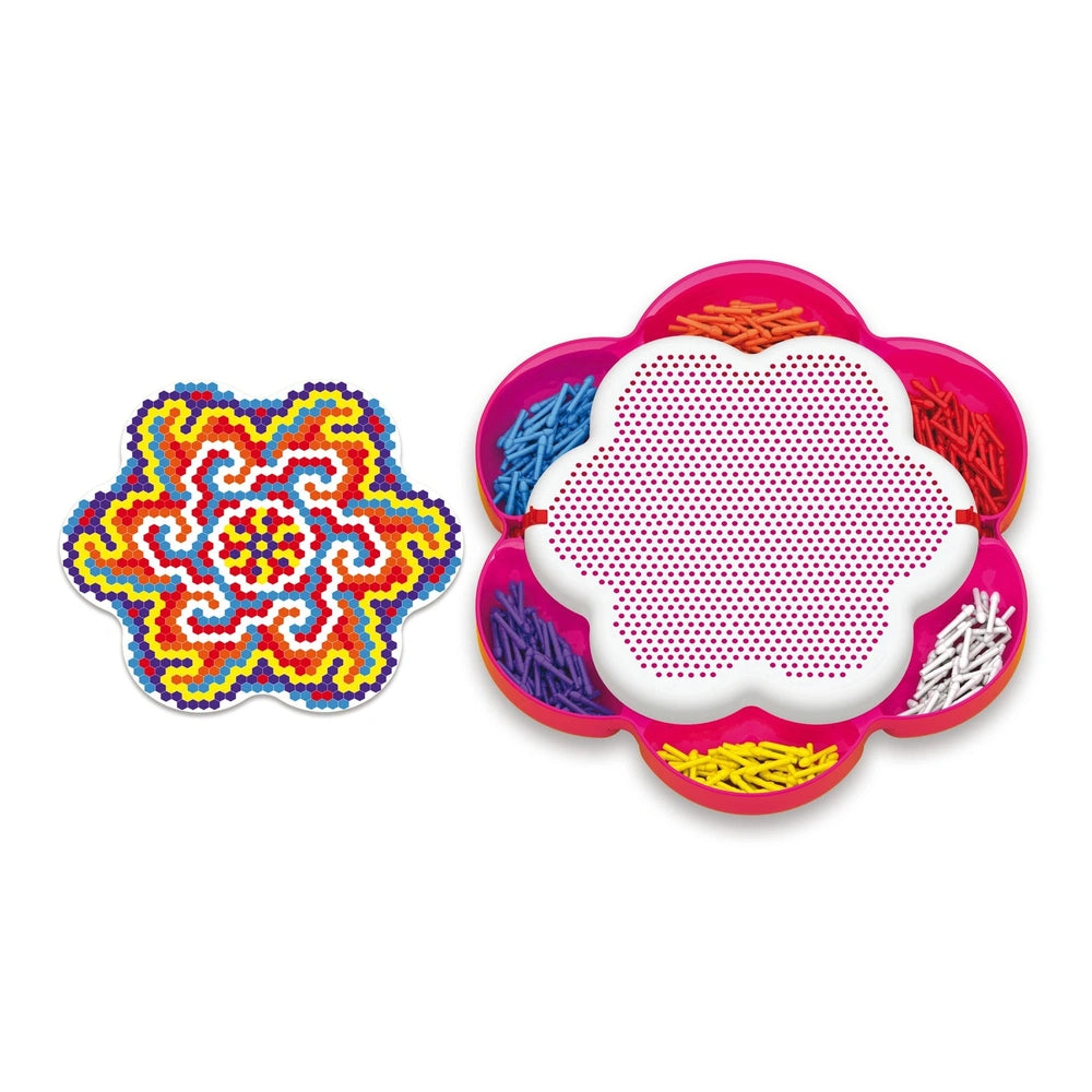 Quercetti FantaColor Mandala features a colorful foreground pattern with red, yellow, blue, and white against a pink backgrou