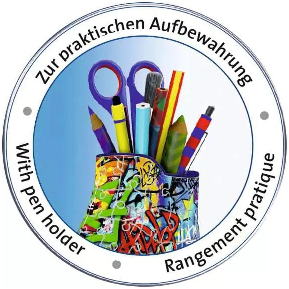 Ravensburger 3D puzzle features colorful art supplies including scissors, a pencil, a paintbrush, and a crayon in a logo desi